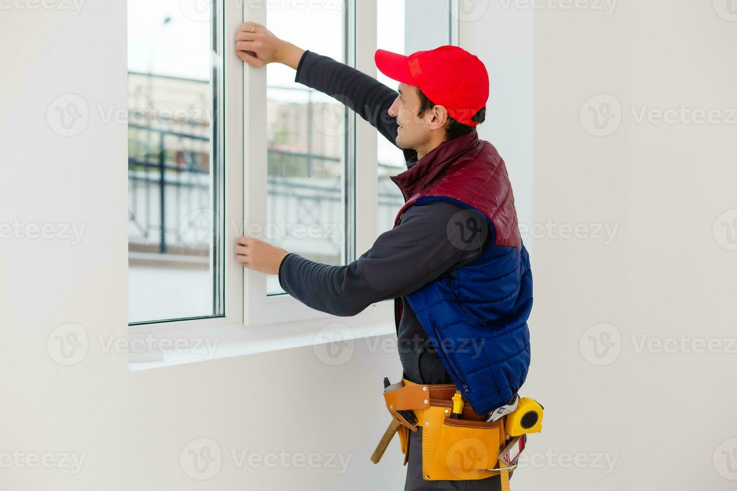 bearded adult repairman fixing window photo