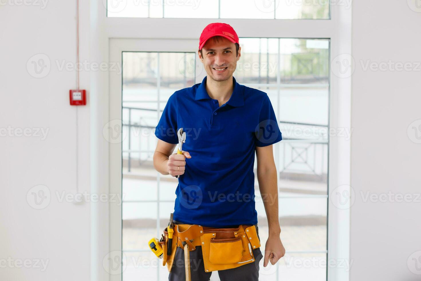 retrato de alegre joven trabajador posando mirando a cámara y sonriente disfrutando trabajo foto