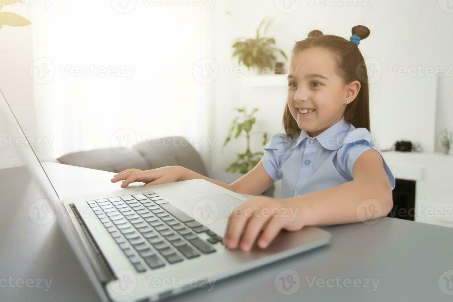 cheerfully cute girl children excited using computer learning schoolwork. kid enjoy e-learning in holiday at home. photo