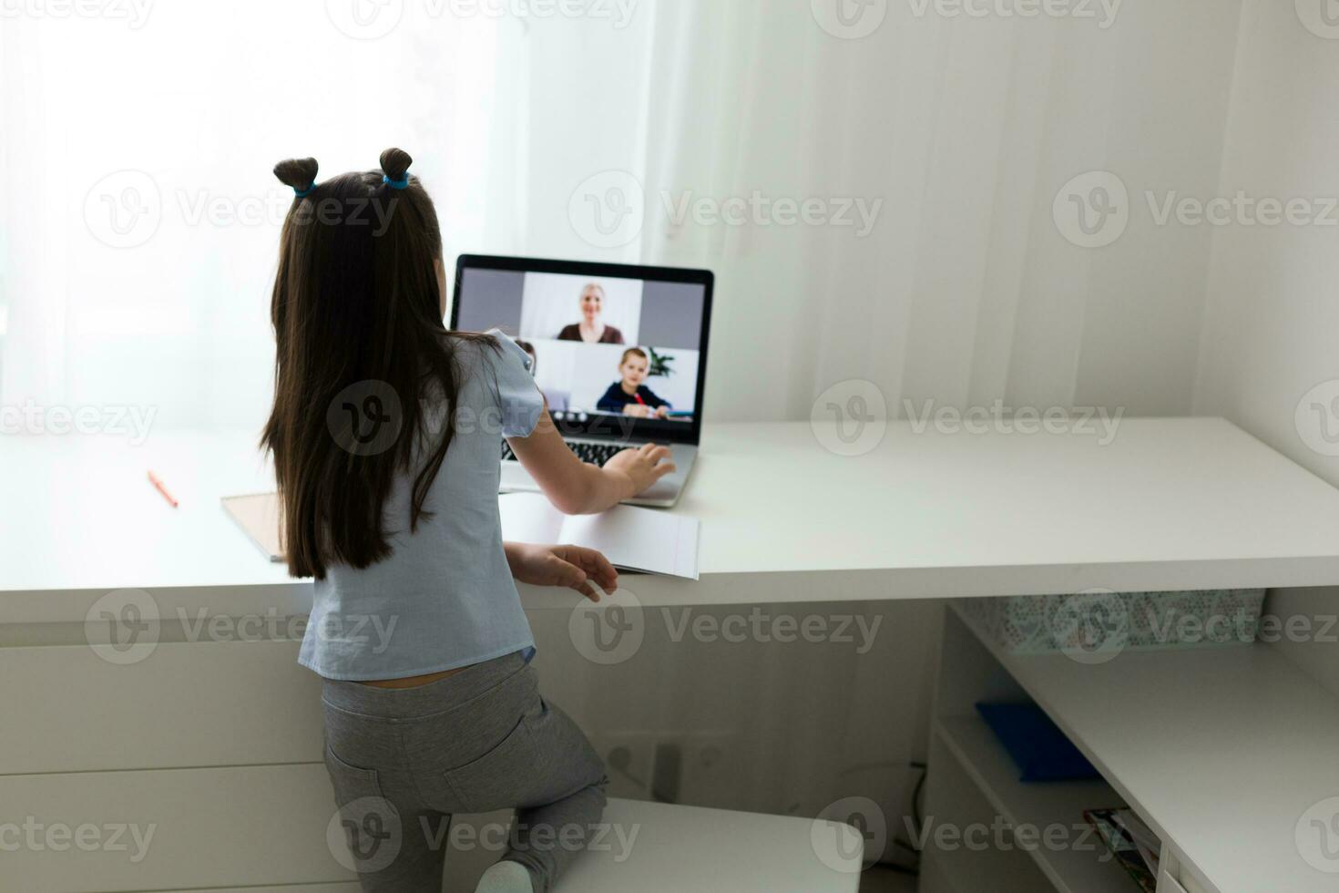 Pretty stylish schoolgirl studying homework math during her online lesson at home, social distance during quarantine, self-isolation, online education concept, home schooler photo