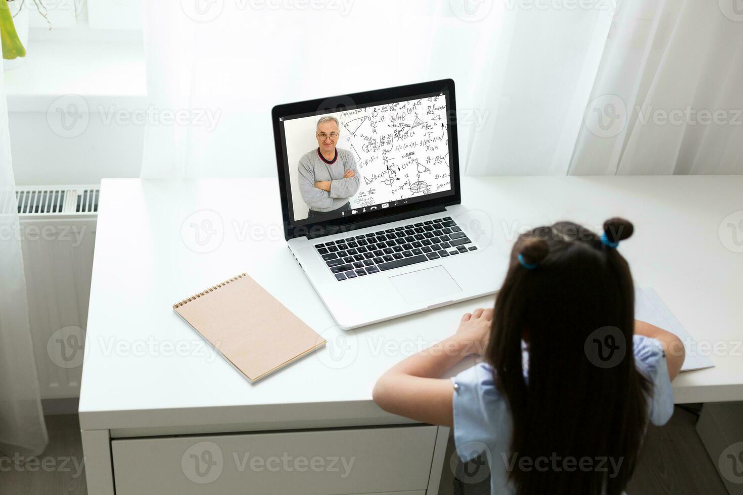 bonito elegante Chica de escuela estudiando deberes matemáticas durante su en línea lección a hogar, social distancia durante cuarentena, autoaislamiento, en línea educación concepto, hogar escolar foto