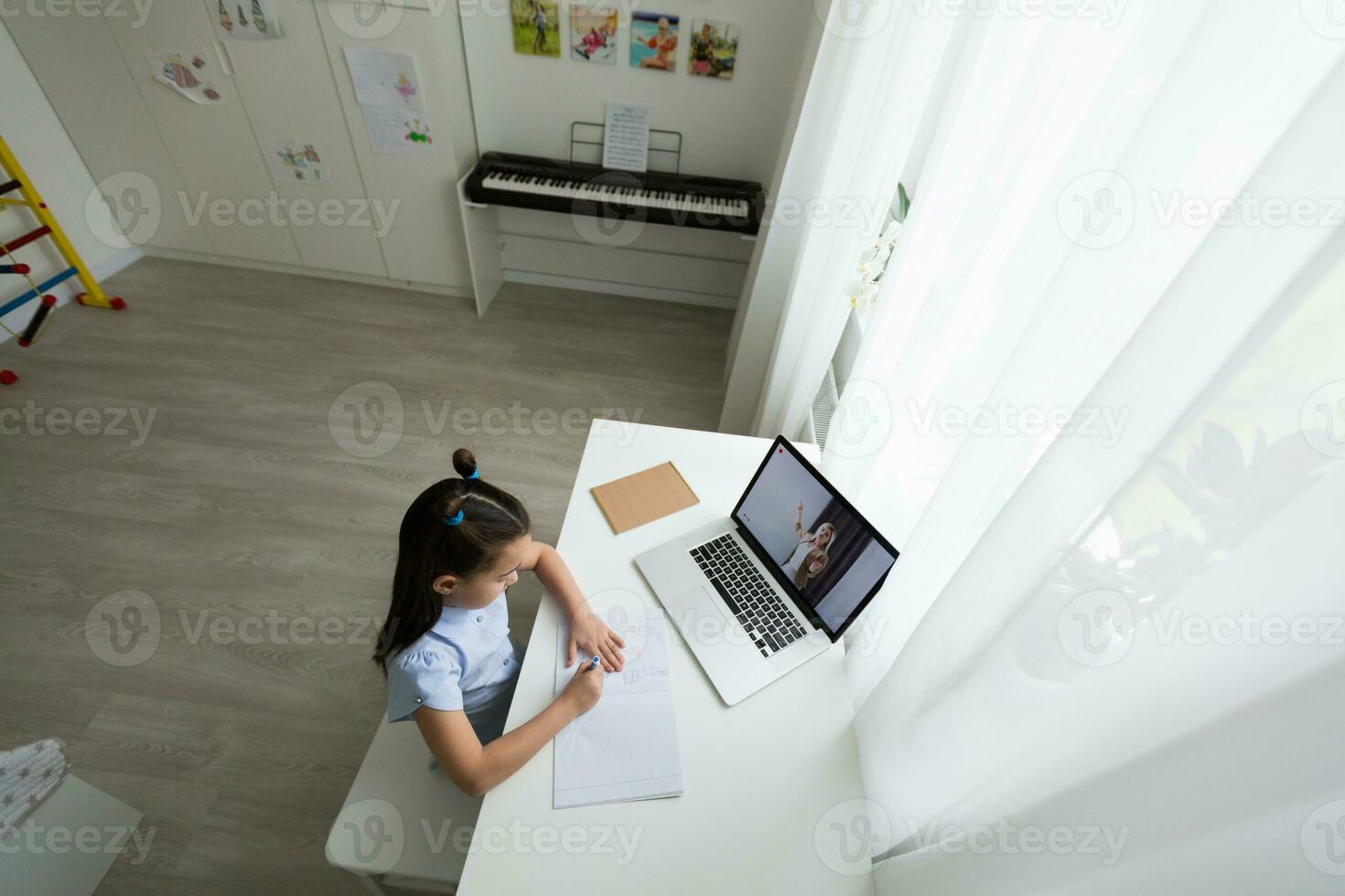 pequeño niña estudiando con ordenador portátil en línea aprendizaje foto