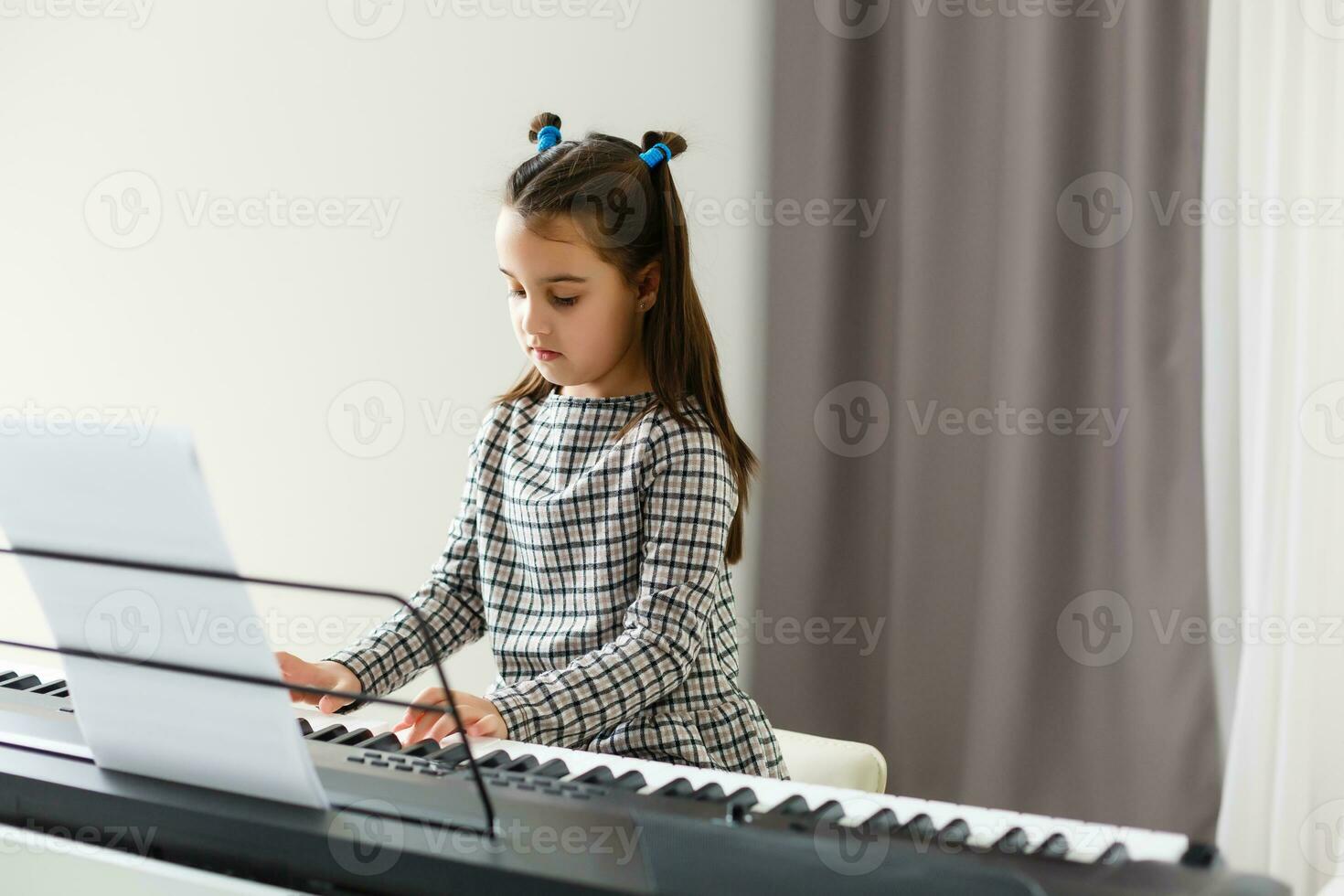 beautiful girl with lounge curl playing a piano in apartment photo