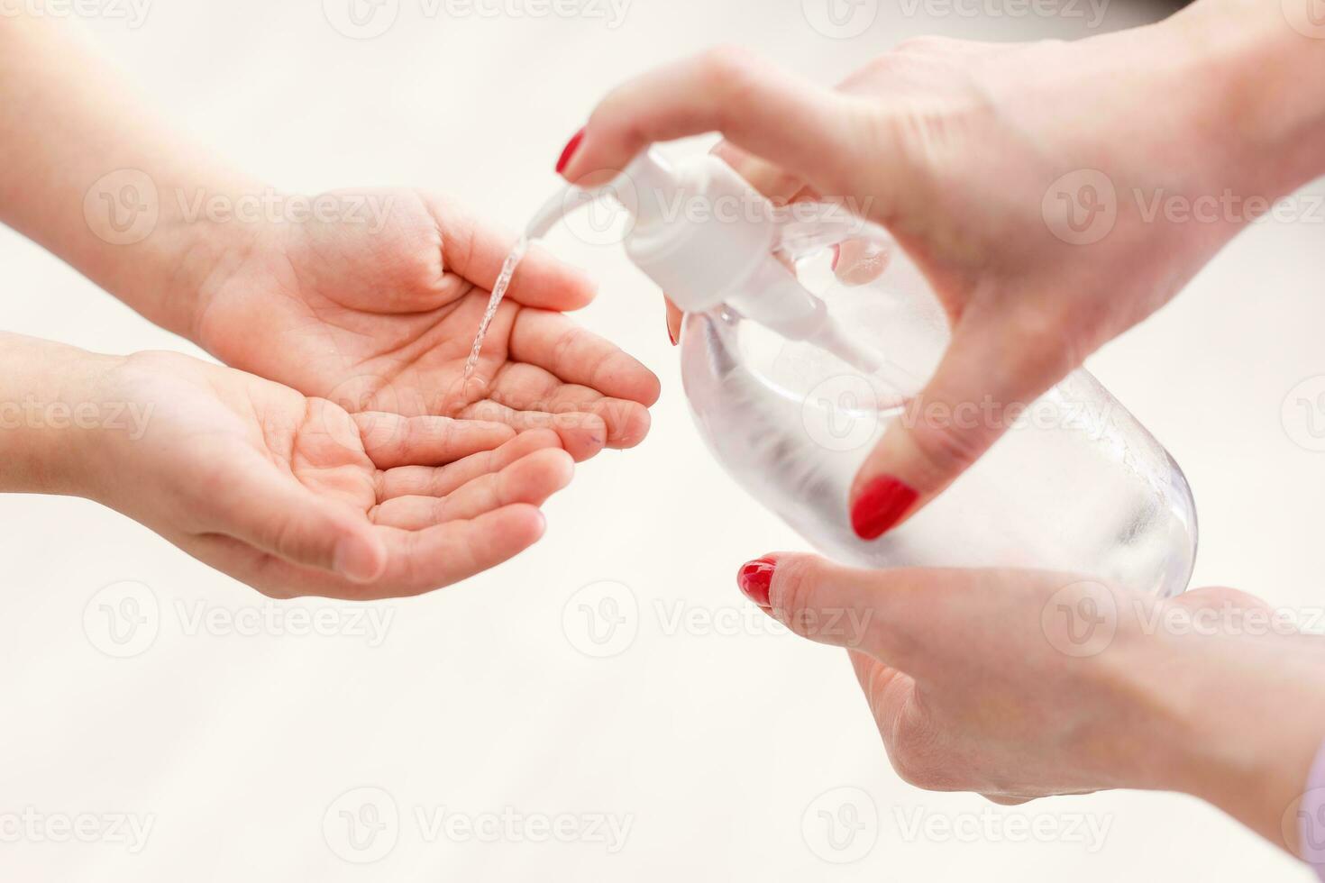 Close up mother applies disinfectant to her daughter to prevent infection. Family hygiene concept. photo