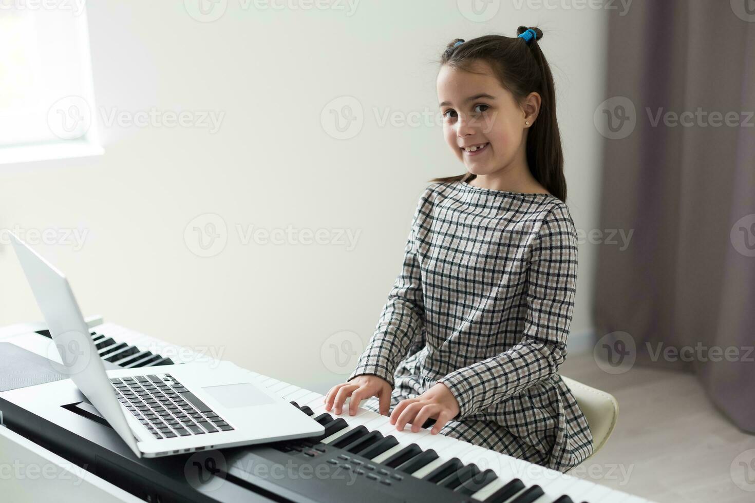 Home lesson on music for the girl on the piano. The idea of activities for the child at home during quarantine. Music concept photo