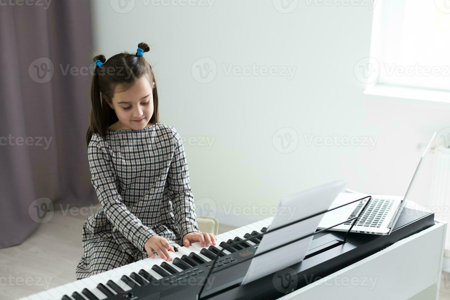 beautiful girl with lounge curl playing a piano in apartment photo