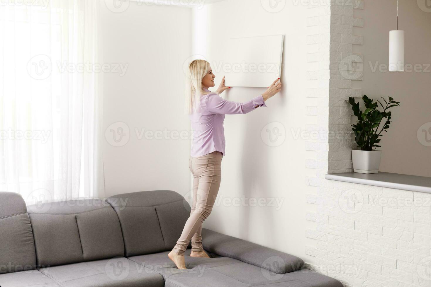 Happy european girl holding a blank canvas in her hands. Empty frame for text or photo. Young woman with mockup poster photo