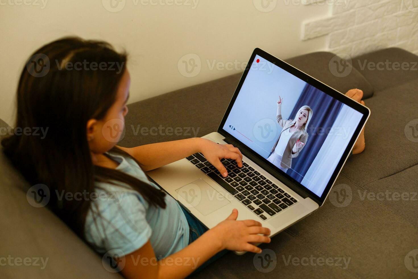 Head shot close up portrait of happy small pupil learning at home. Smiling little child girl enjoying doing lessons in living room. Smart kid schoolgirl looking at camera, studying remotely online. photo