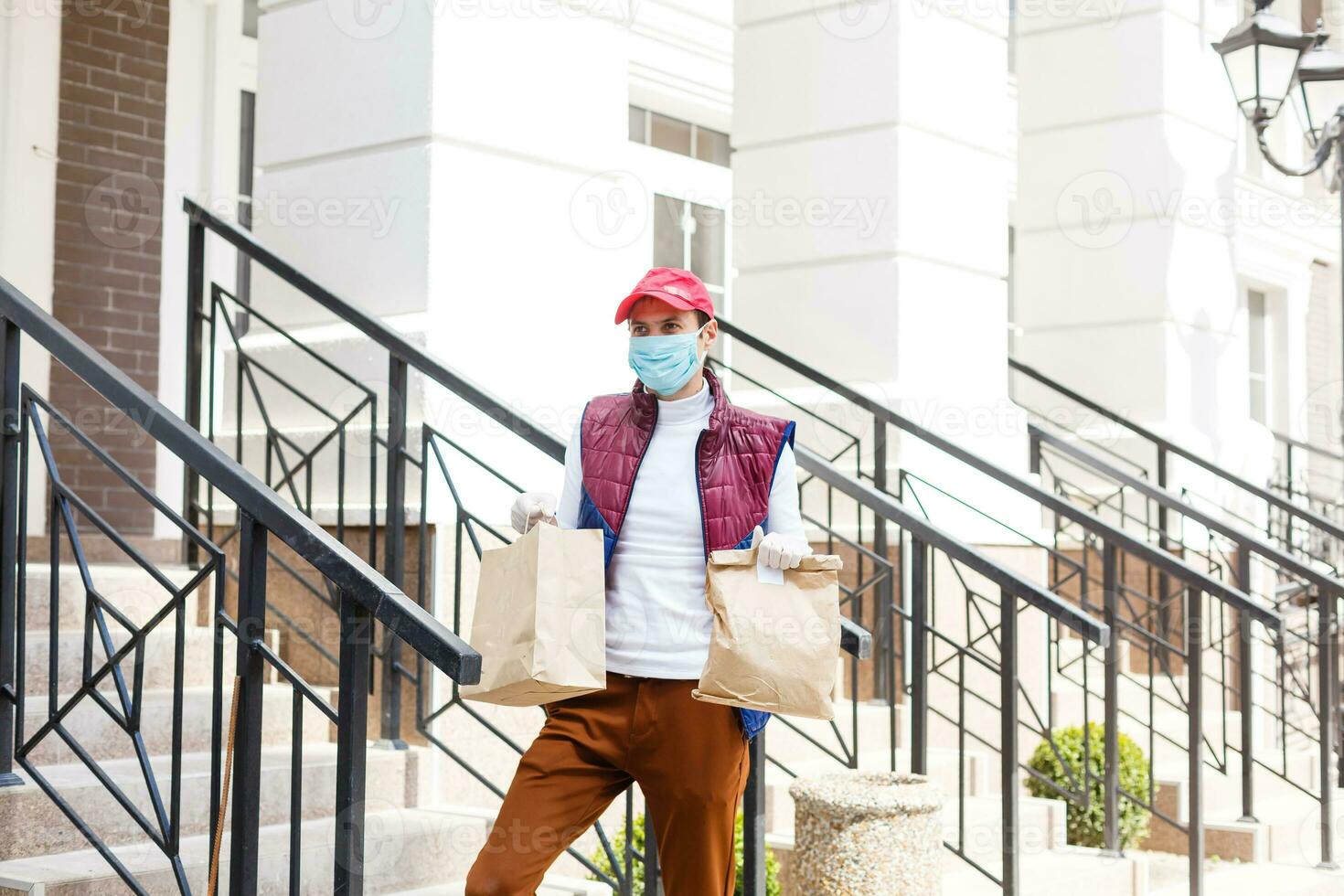 Man with face mask is delivering food and groceries during virus epidemic. photo