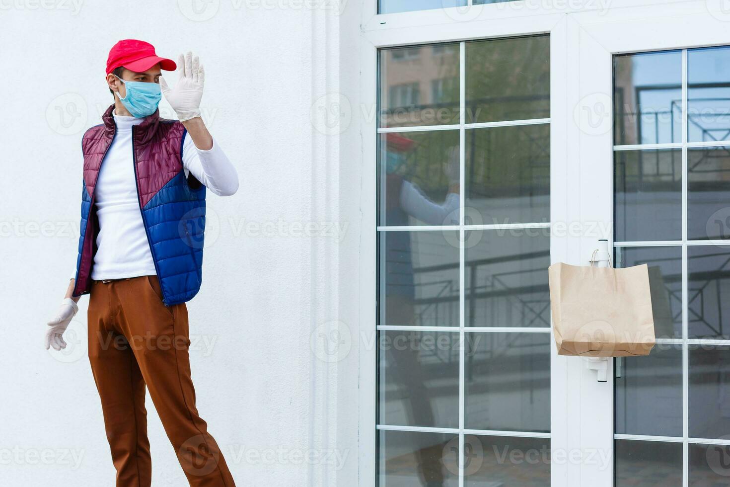 Grocery delivery man wearing medical gloves and face mask. Online shopping and delivery for grocerys, wine and food. Self Quarantine during coronavirus pandemic. Food delivery service courier photo
