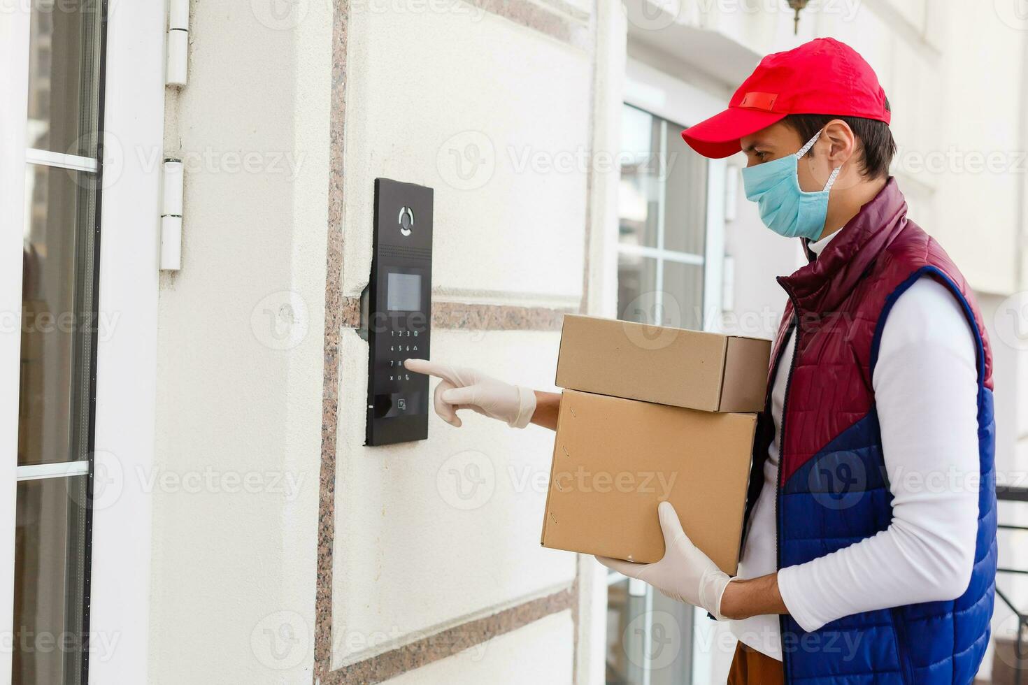 Delivery man holding paper bag with food on white entrance of house background , food delivery man in protective mask photo