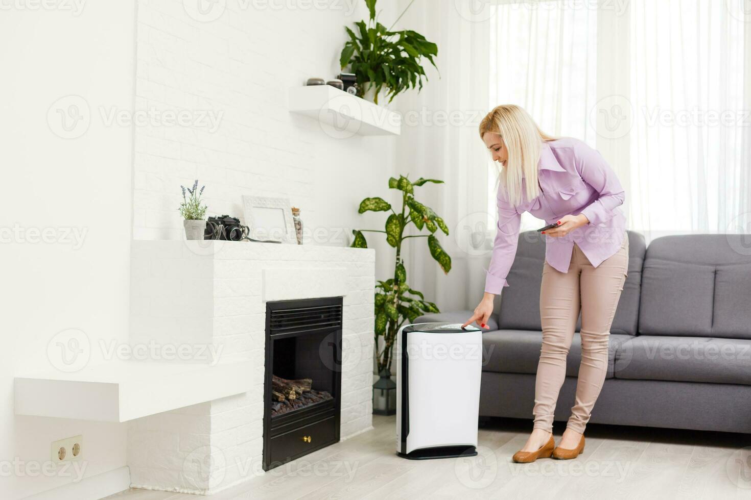 aire purificador , negocio mujer trabajando con ordenador portátil utilizar teléfono con filtrar para limpiar habitación en un vivo habitación foto