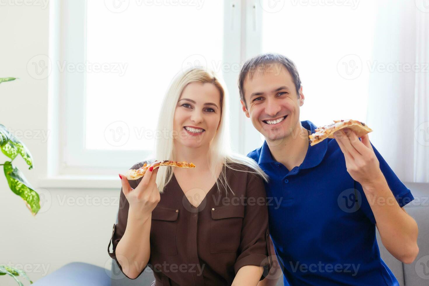 hombre y mujer comiendo un Pizza y disfrutando el noche foto