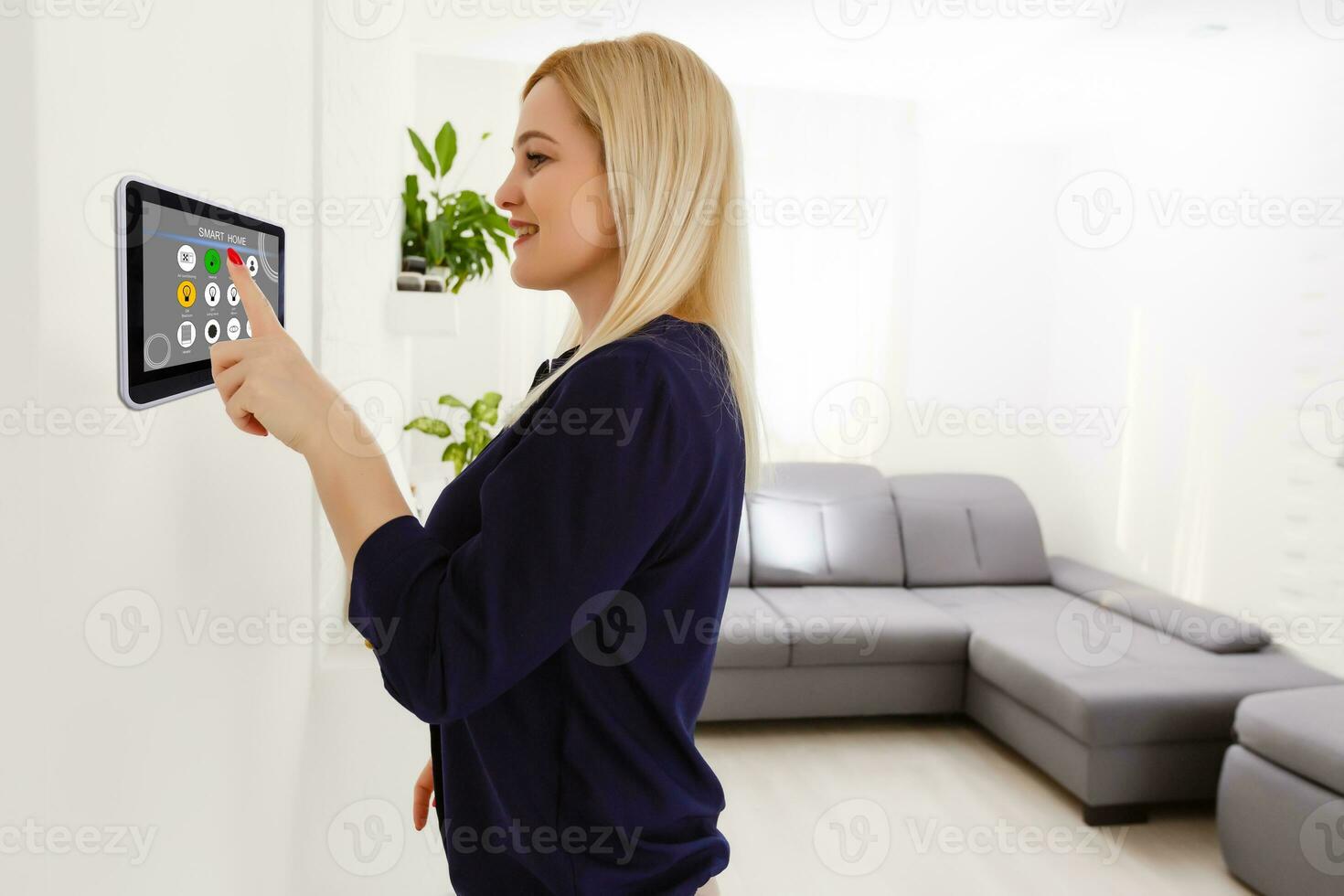 inteligente casa. bonito alegre mujer mirando a el sensorial panel mientras prensado eso foto