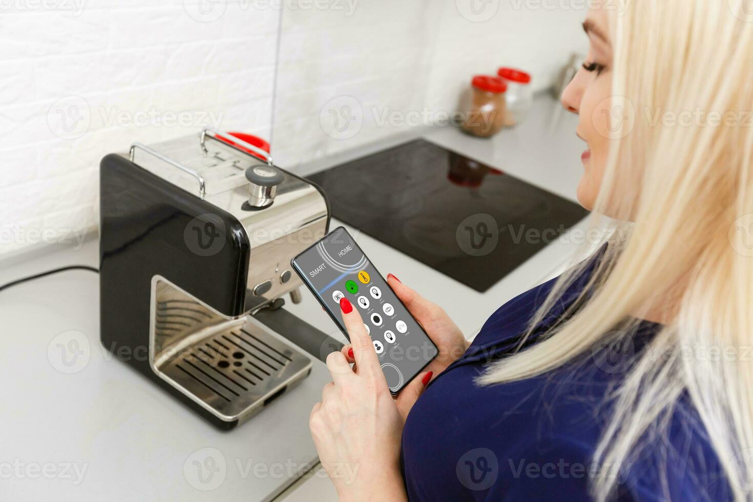 girl sitting on the sofa and holding a phone with program smart home on the screen photo