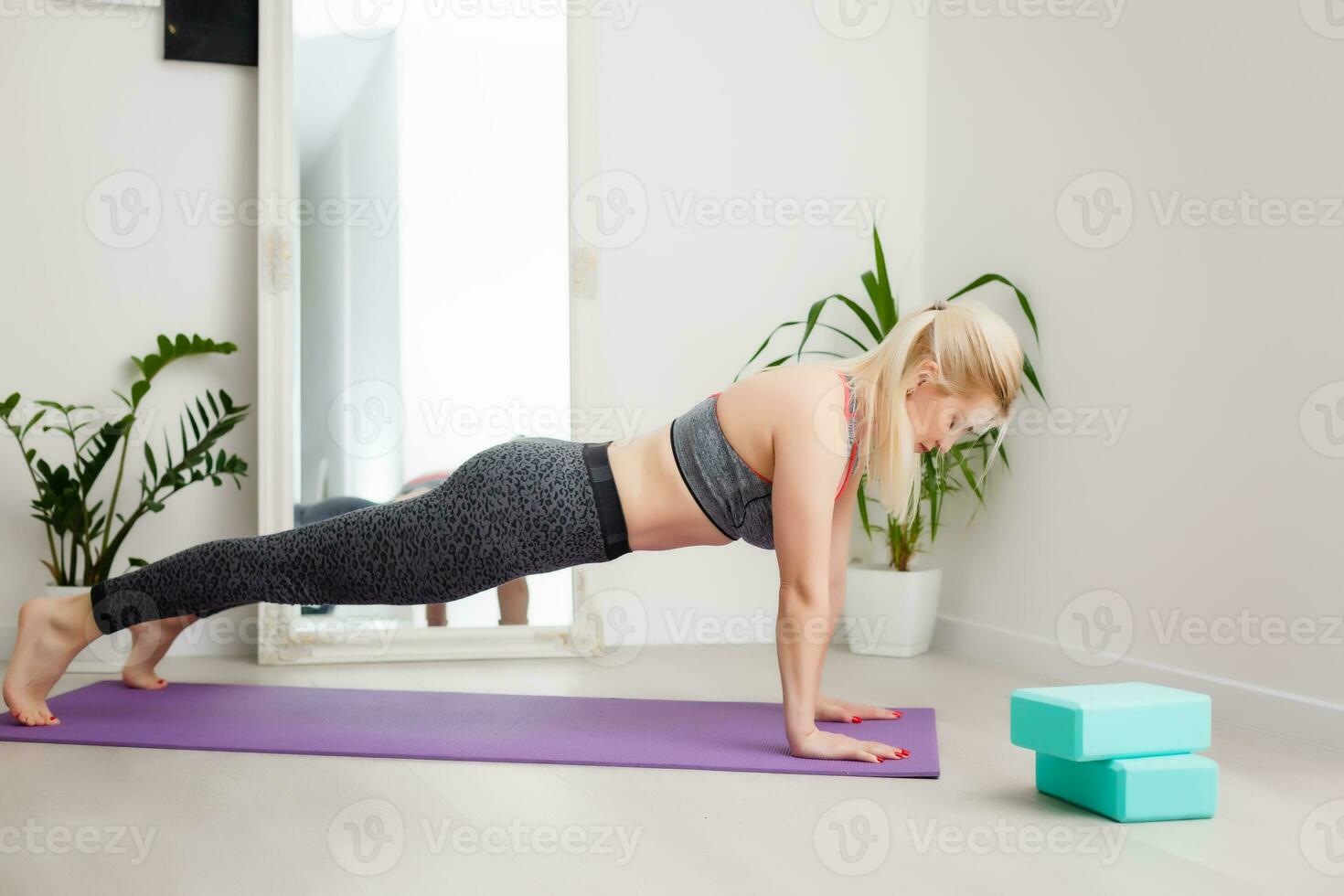 Living room fitness workout girl doing exercises at home. Young woman training muscles, healthy lifestyle without going to the gym. photo
