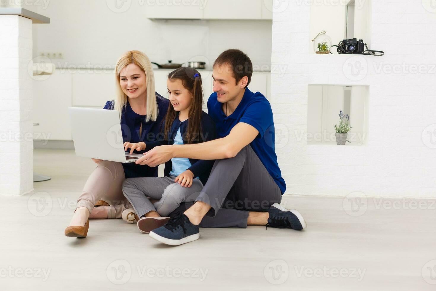 Family top view sitting on floor using laptop computer in her room at home photo