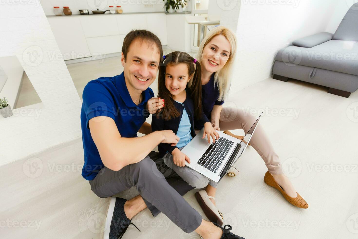 contento padres con hija utilizando ordenador portátil a hogar foto