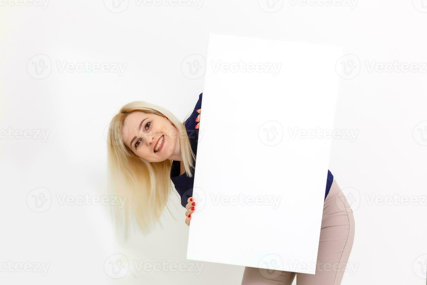 Girl and blank canvas. Copy space on canvas board for image or message. Young woman looking at mockup poster and standing over grey background. photo