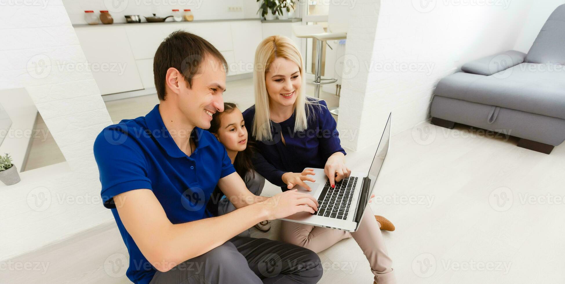 Happy family chatting online using laptop while sitting with baby at home. photo