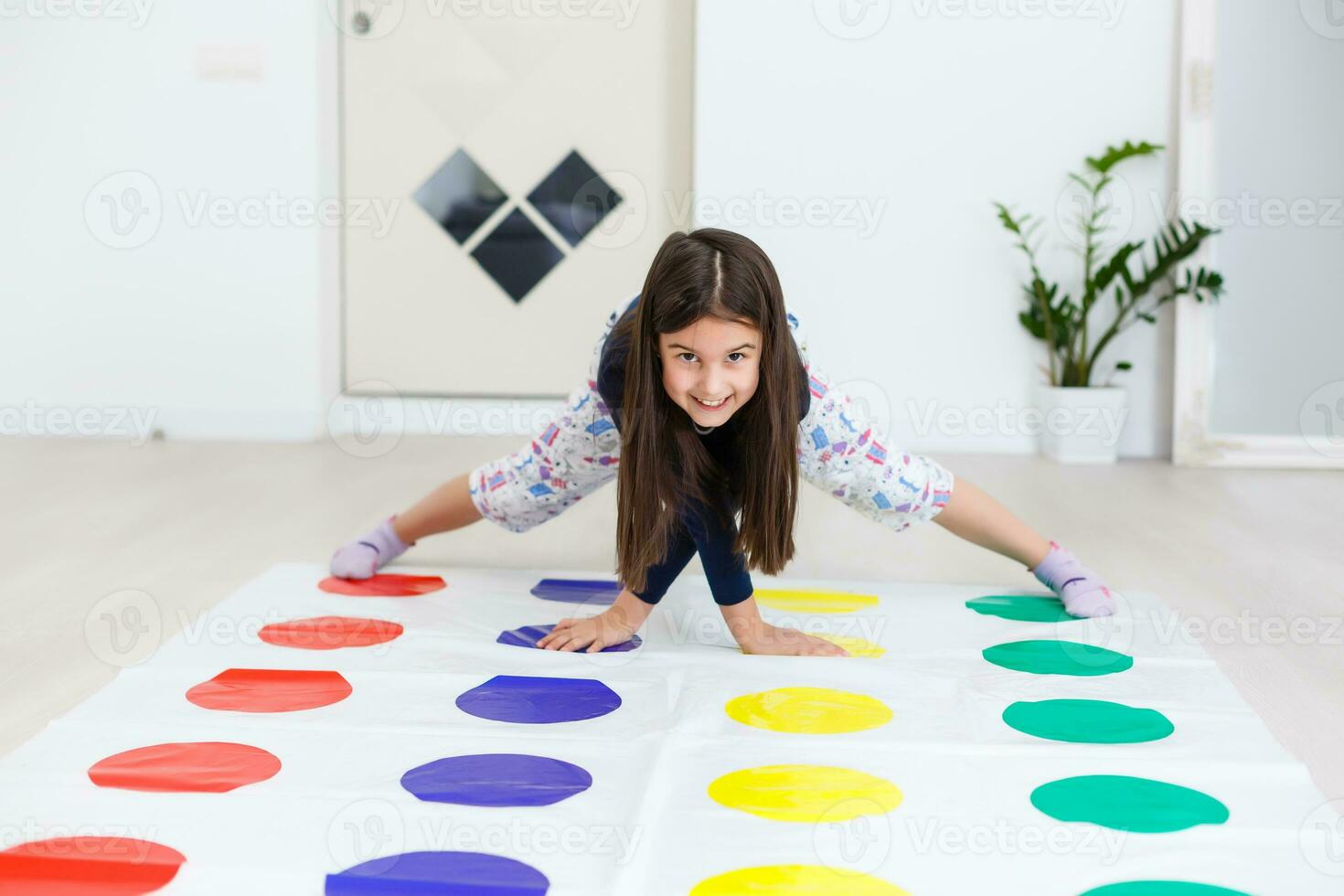 pequeño niña jugando en un tornado juego a hogar. niña sonrisas y mira arriba foto