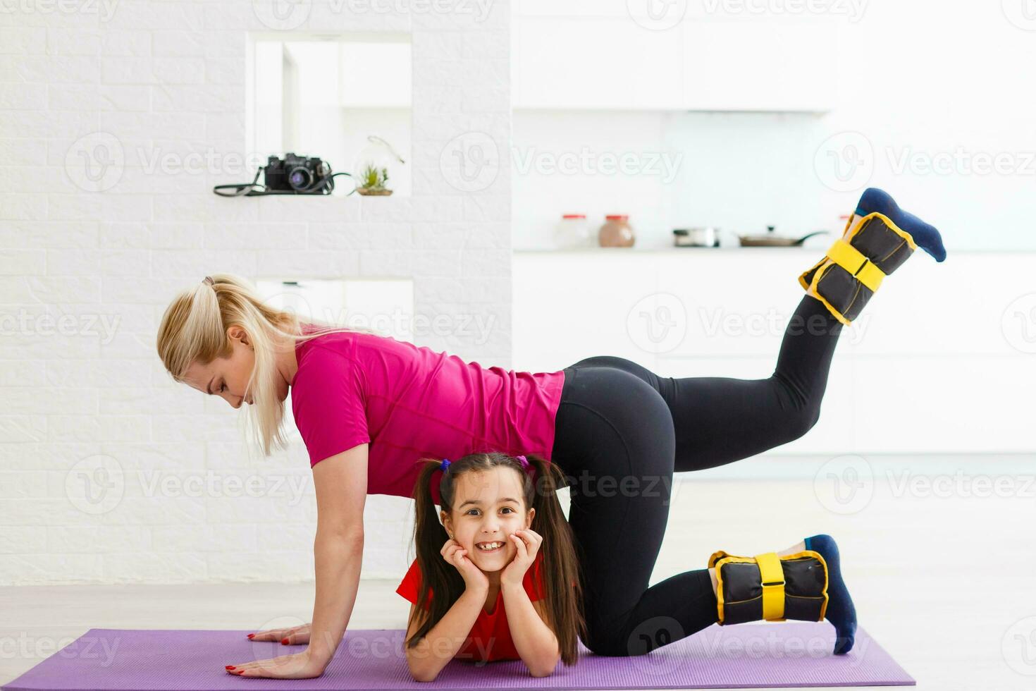 Mother and daughter doing exercises on mat at home. photo