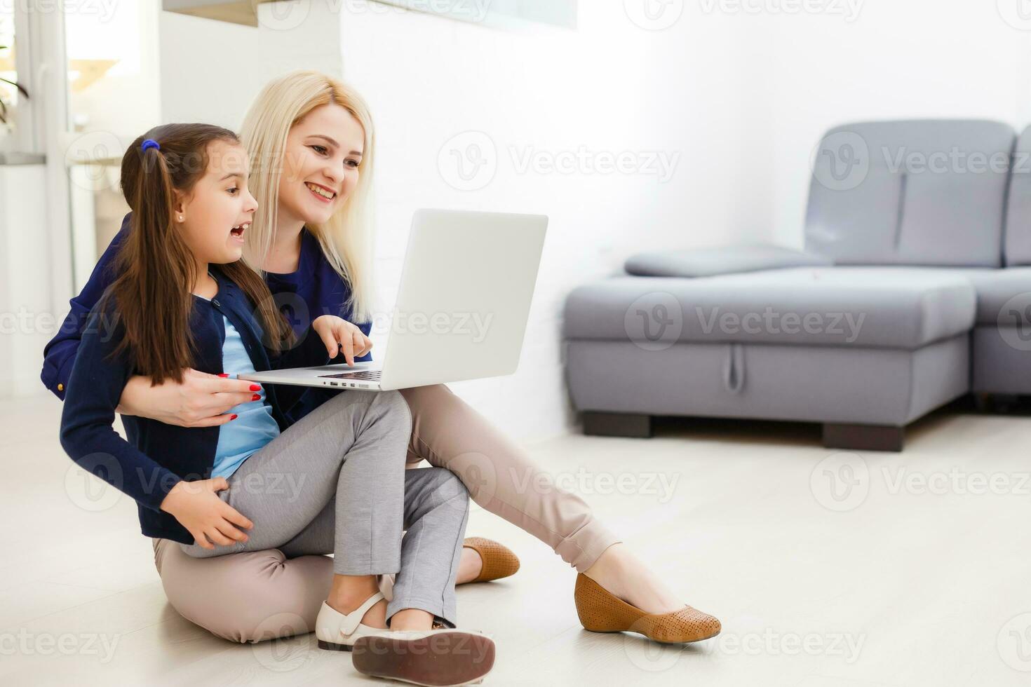 education, family and distant learning concept - mother and daughter with laptop computer doing homework together at home photo