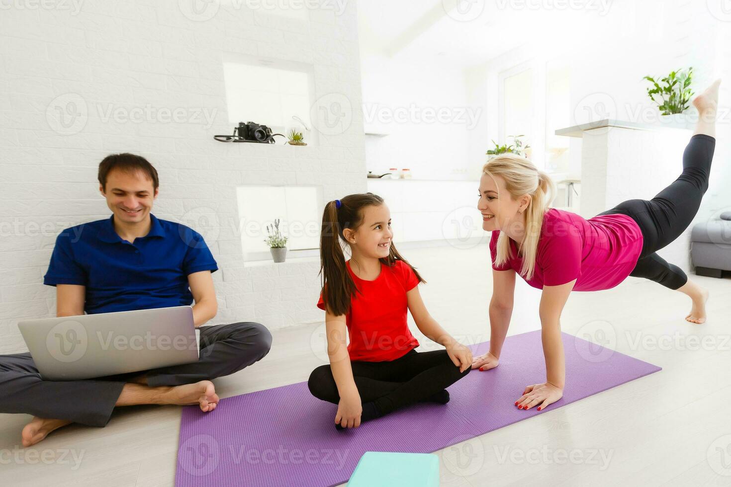 Mother and daughter doing yoga exercises on mat at home. photo