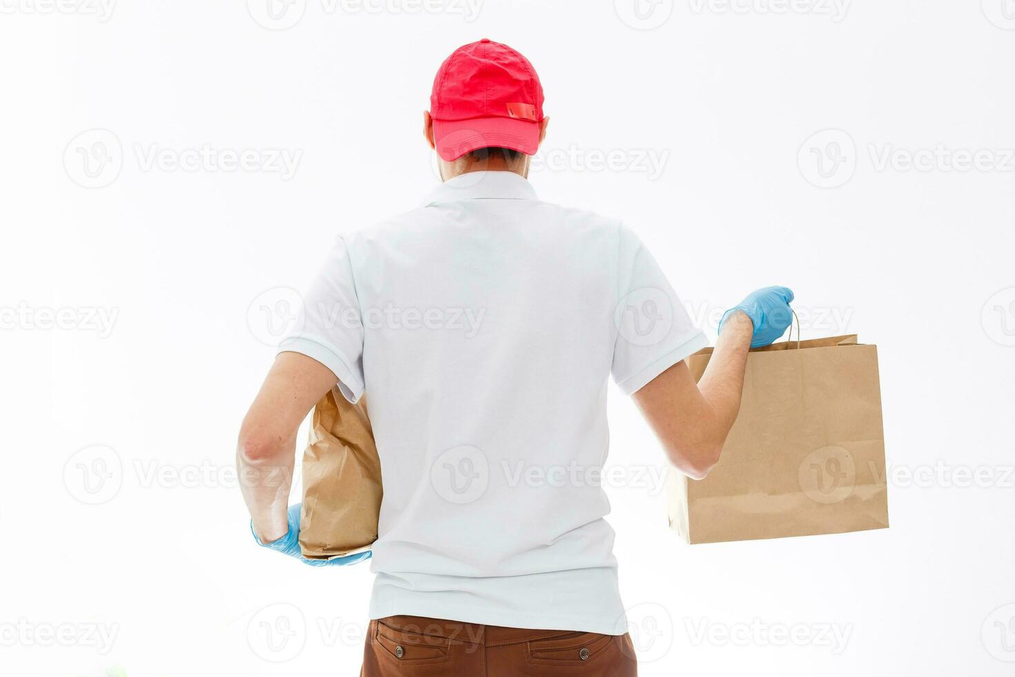 Courier in protective mask and medical gloves delivers takeaway food. Delivery service under quarantine, disease outbreak, coronavirus covid-19 pandemic conditions. photo