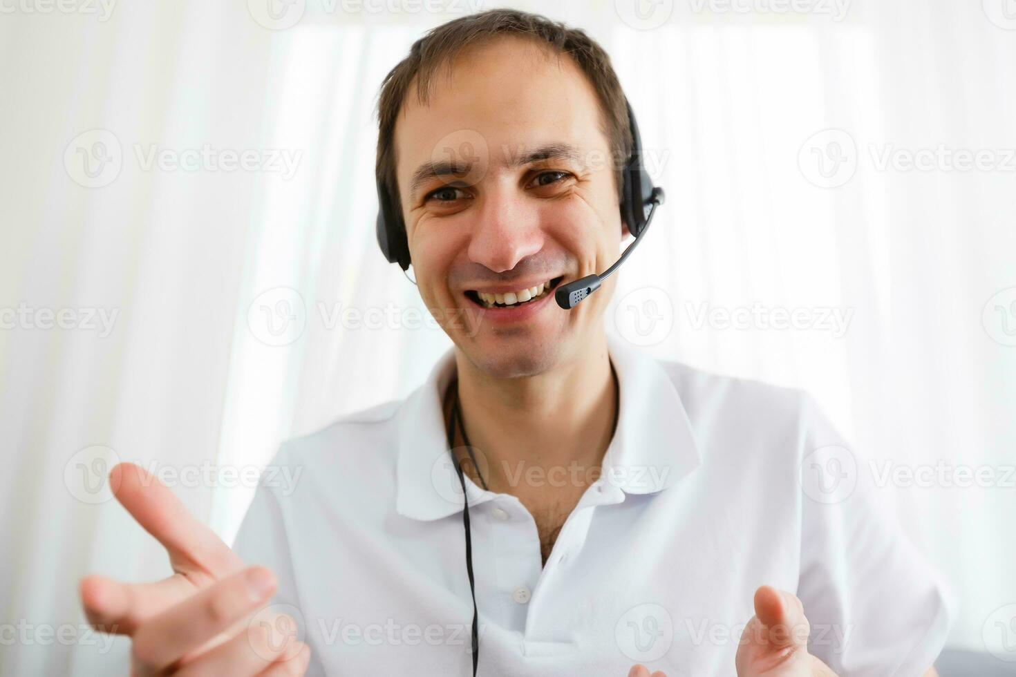Happy Businessman in the office on the phone, headset, Skype. looking camera photo