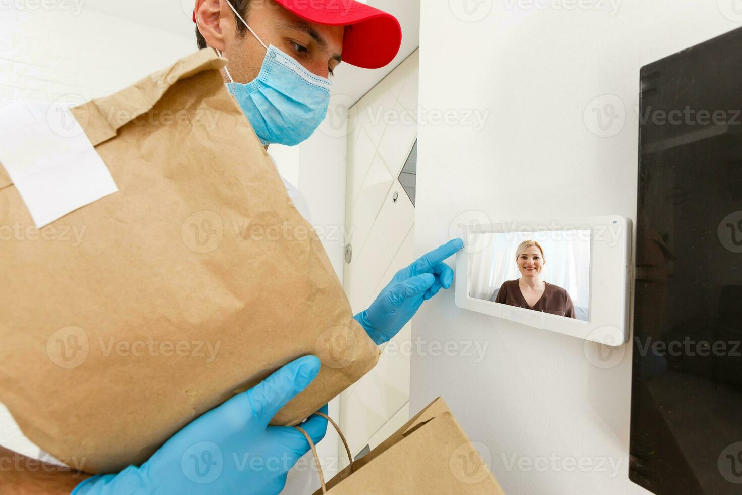 home delivery, online order. A man in uniform, a medical mask and rubber gloves with a box, a parcel in his hands. Food and food delivery during the quarantine of the coronavirus pandemic photo