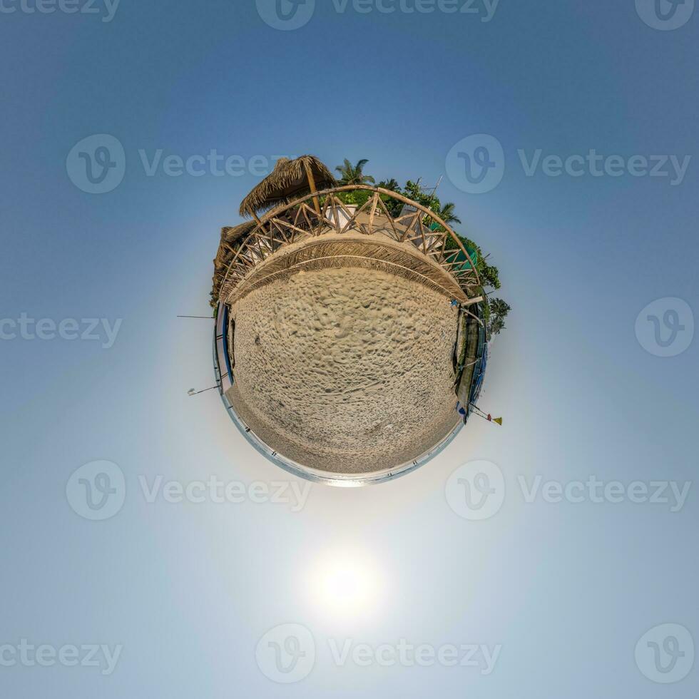 coconut trees in jungle in Indian tropic village on sea shore with fisher boat on little planet in evening sky, transformation of spherical 360 panorama. photo