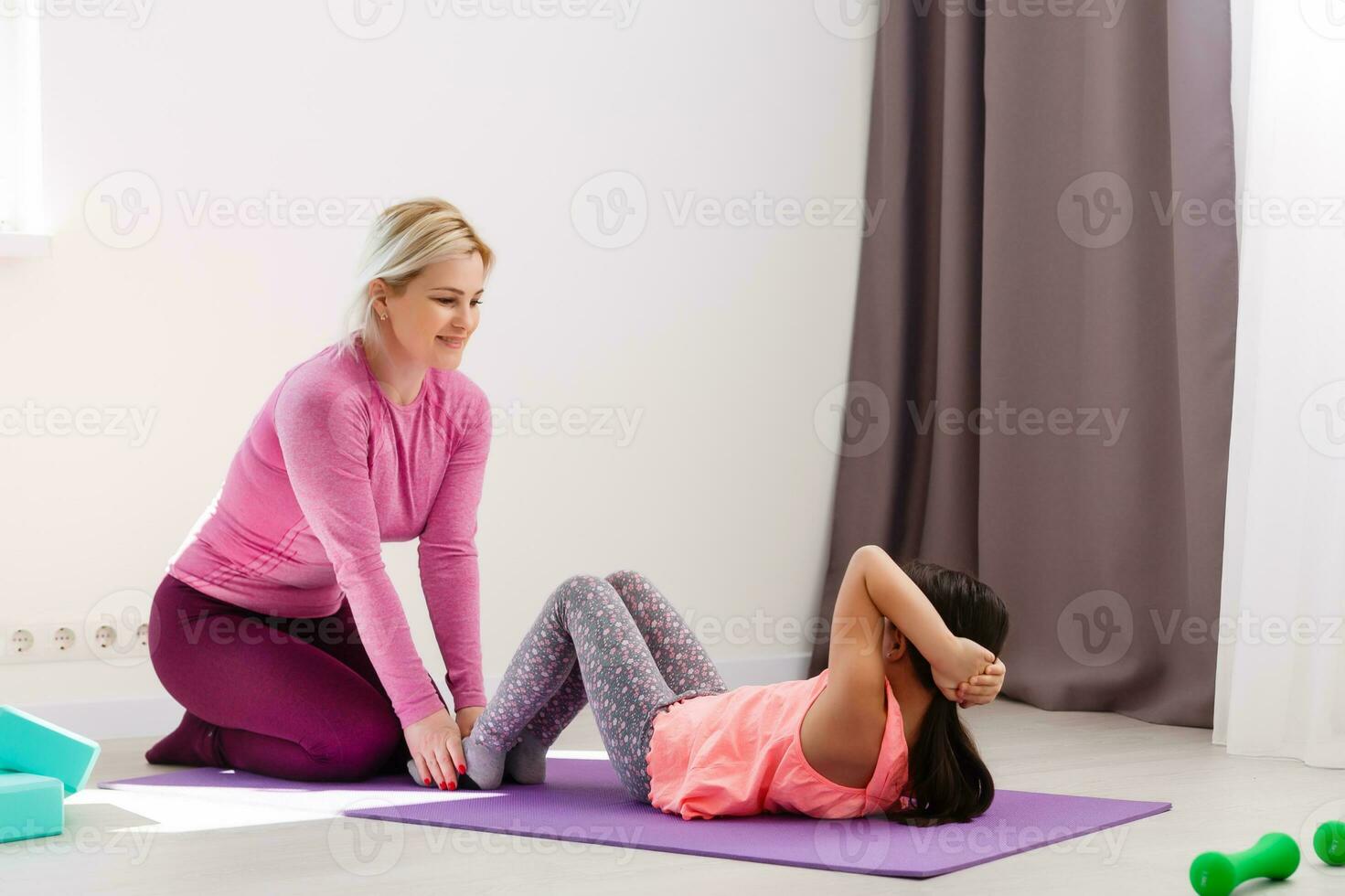The girl does gymnastics at home. Gymnastics video tutorial. Gymnastic exercises. The idea for a children's activity in quarantine photo