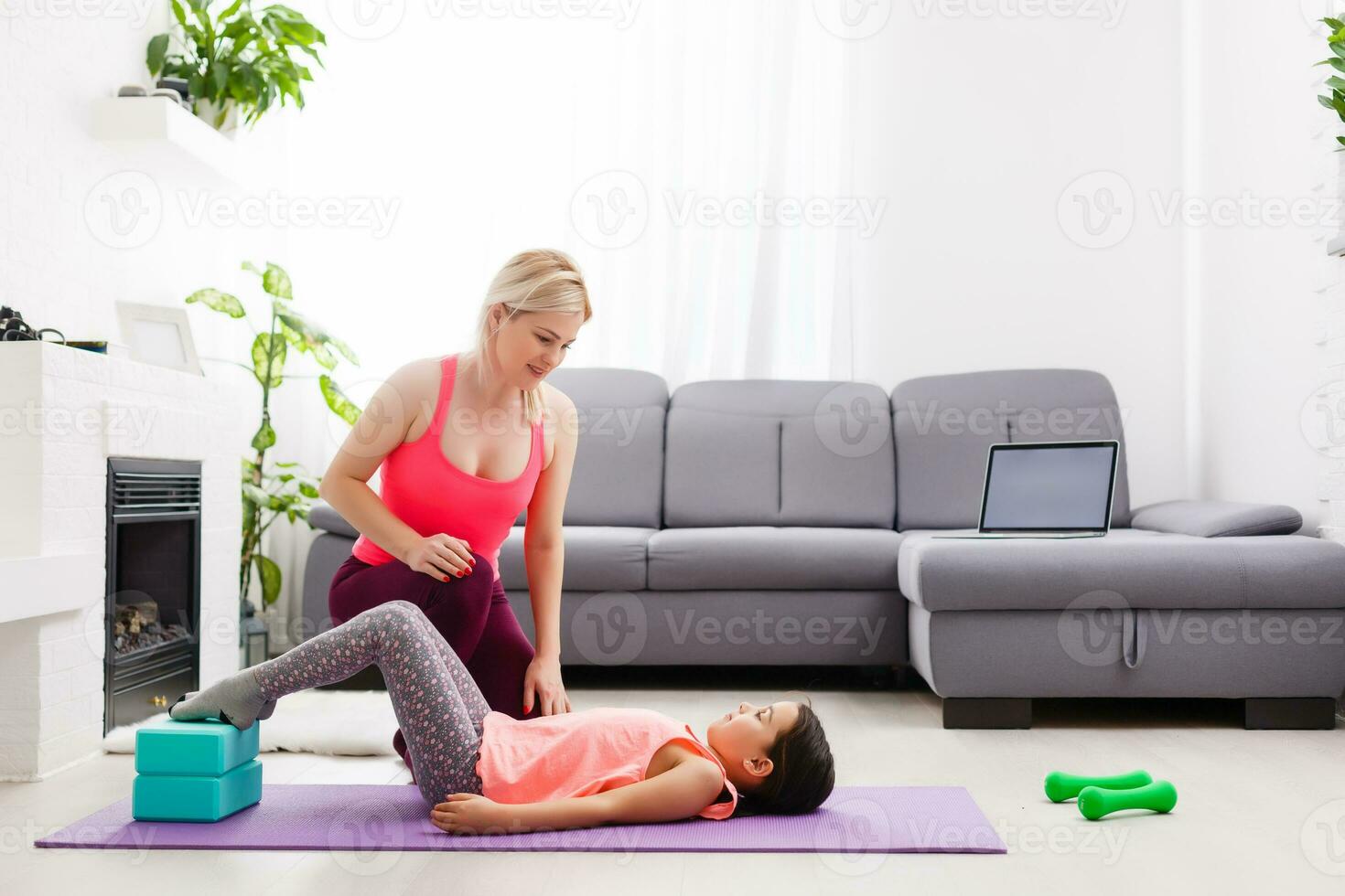 The girl does gymnastics at home. Gymnastics video tutorial. Gymnastic exercises. The idea for a children's activity in quarantine photo