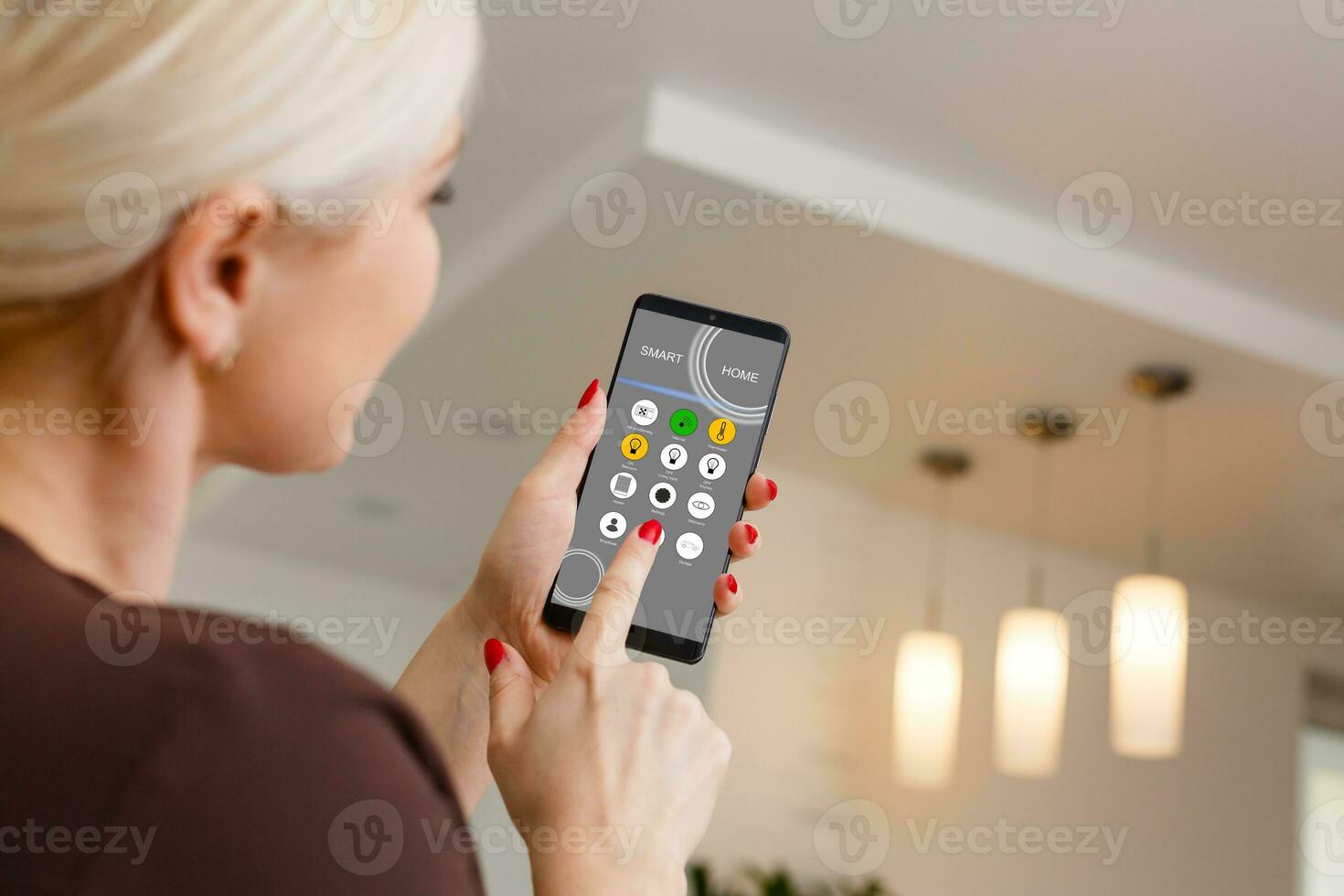 Smart Home Woman Controlling Lights With App On His Phone photo