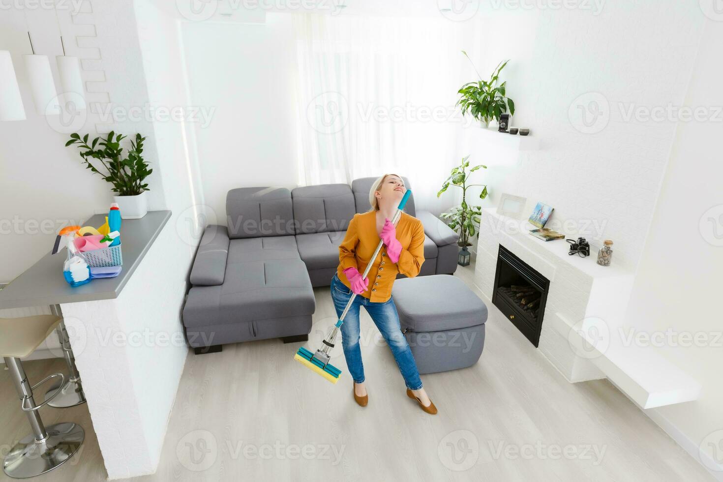 joven mujer con limpieza de la casa engranaje bailes en el vivo habitación. foto