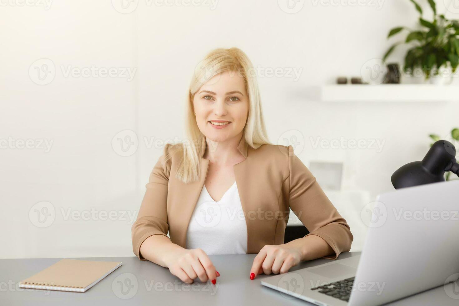 retrato de contento experto medio Envejecido mujer vida entrenador, negocio consultor, psicólogo o médico tutor sonriente alegremente a cámara, trabajando en computadora portátil, disfrutando su trabajo, Ayudar personas en línea foto