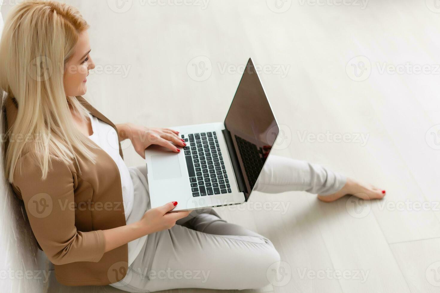 Focused attentive woman in headphones sits with laptop, looks at screen, makes notes, learns foreign language in internet, online study course, self-education on web, consults client by video photo