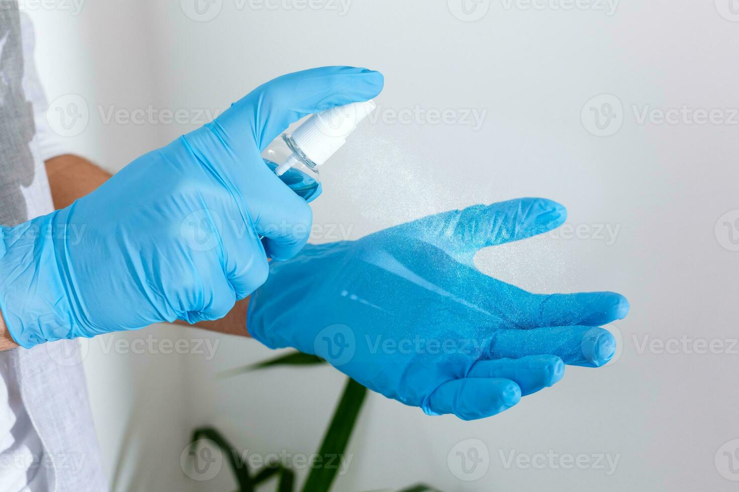 hand in rubber surgical gloves holding antiseptic hand sanitizer on background. alcohol sanitizers or gel for hand hygiene corona virus protection. Antibacterial liquid against covid-19 photo