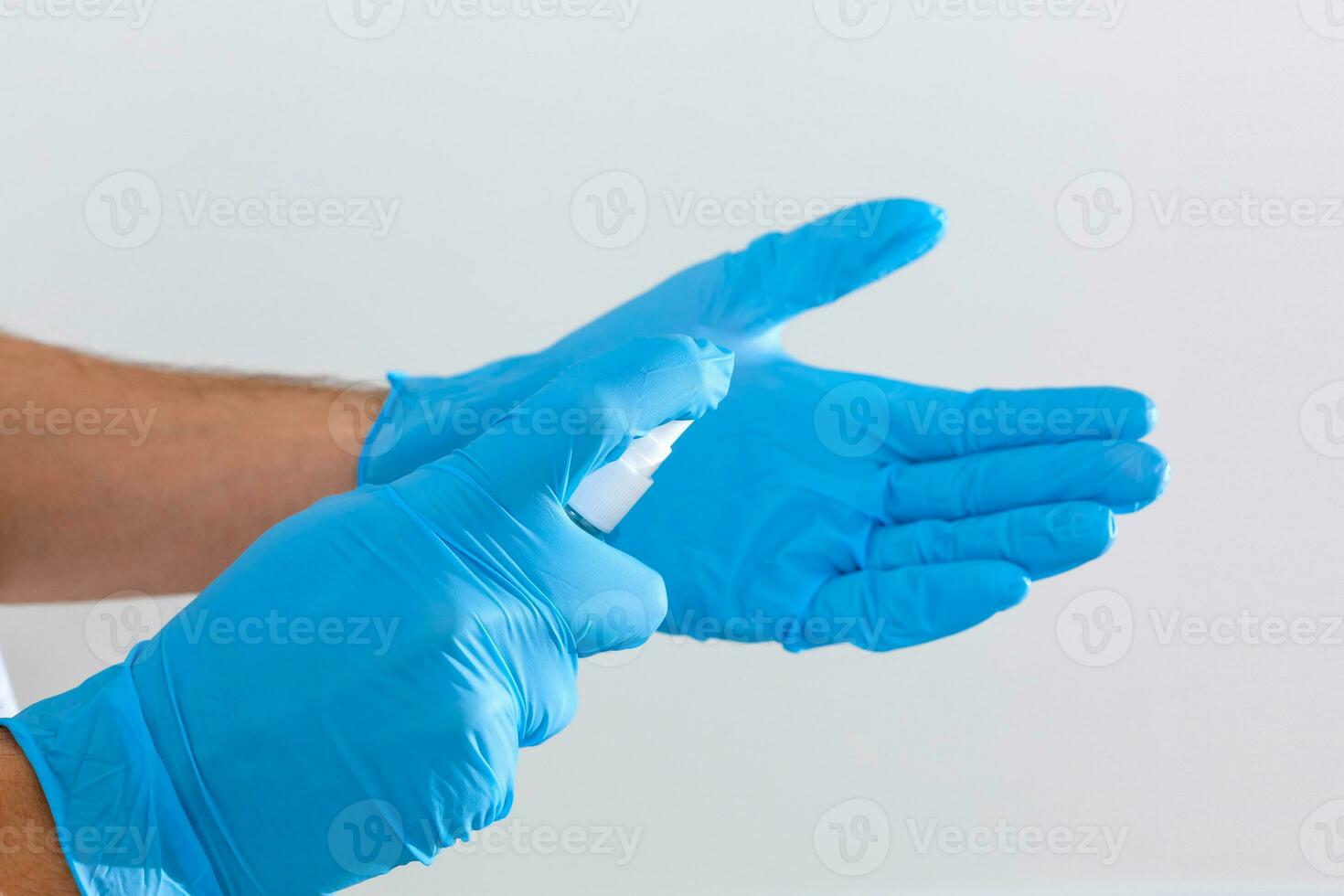 hand in rubber surgical gloves holding antiseptic hand sanitizer on background. alcohol sanitizers or gel for hand hygiene corona virus protection. Antibacterial liquid against covid-19 photo