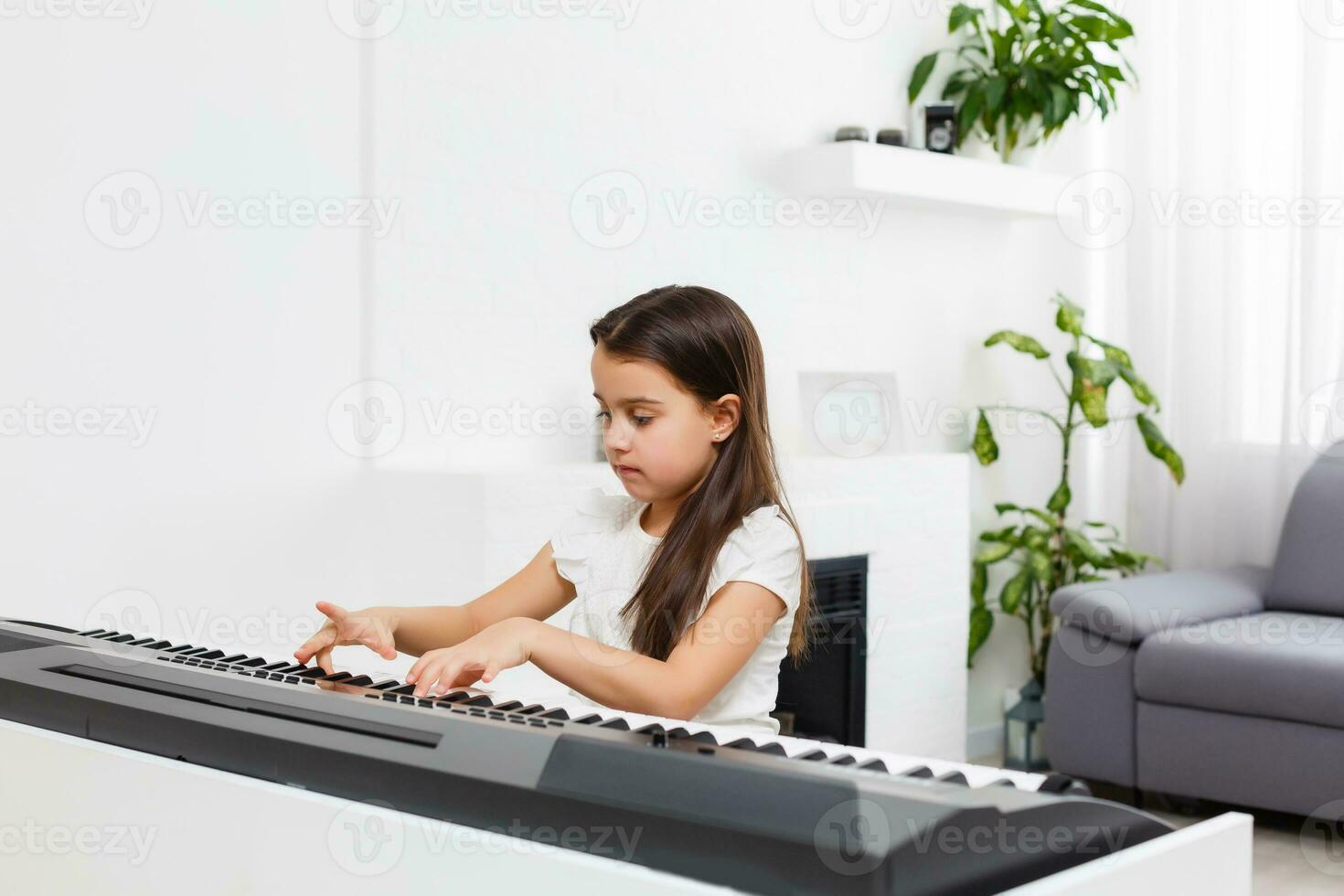 girl playing the piano at home, learning online photo