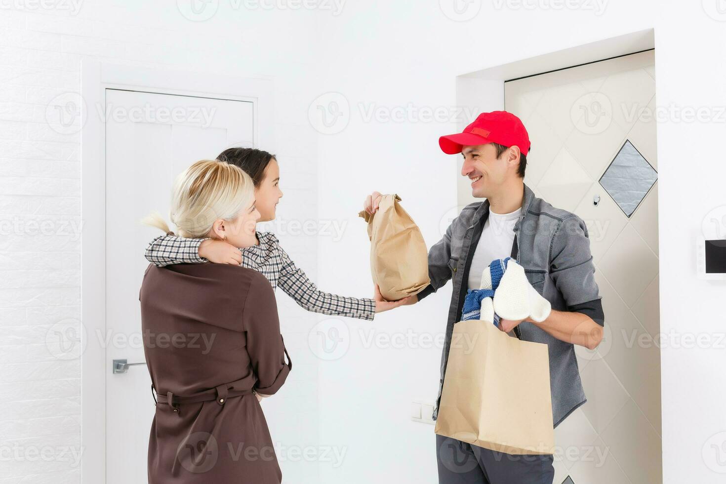 mother and daughter receive order from delivery man, delivery of toys and goods for children at home photo