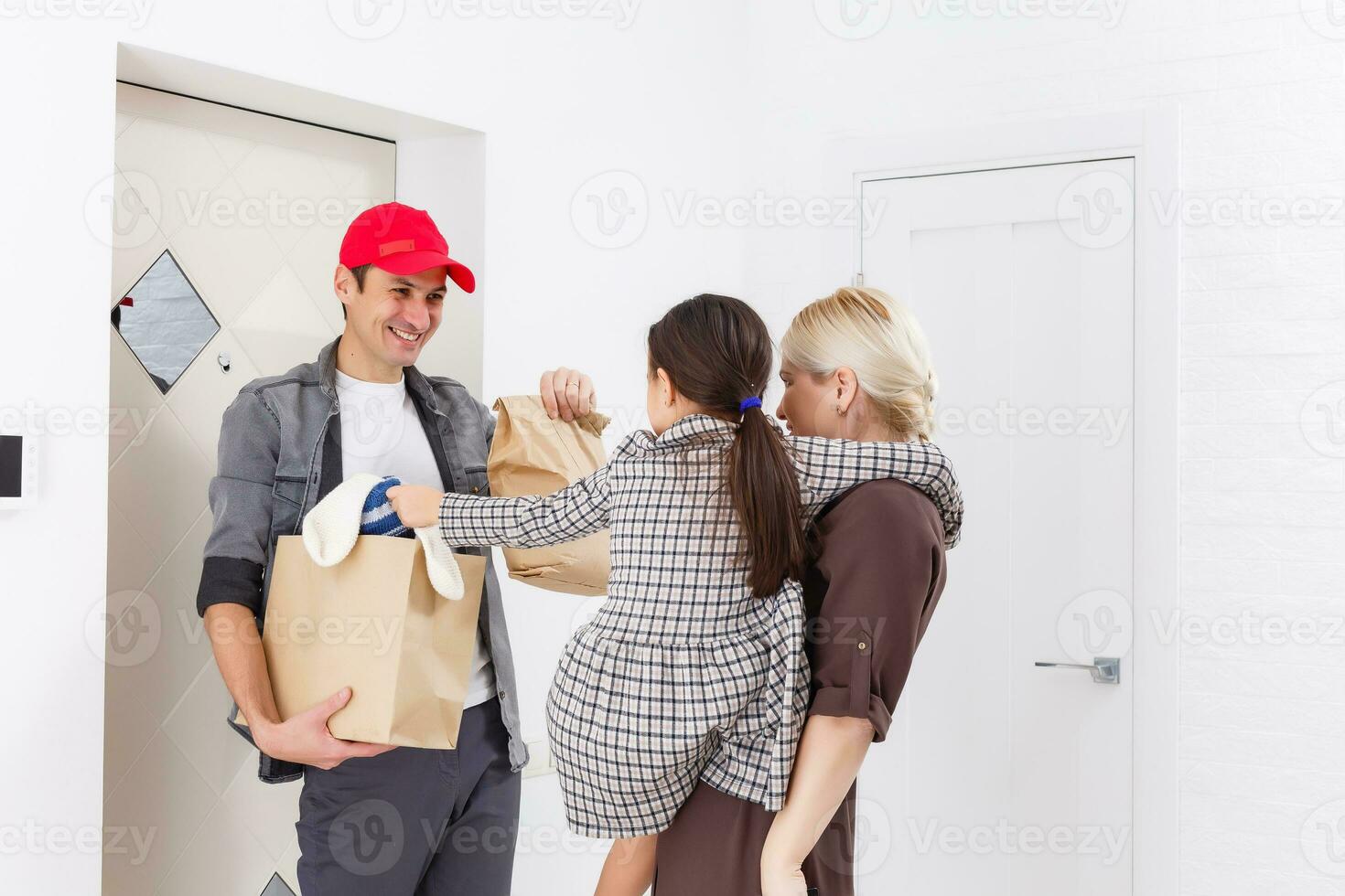 mother and daughter receive order from delivery man, delivery of toys and goods for children at home photo