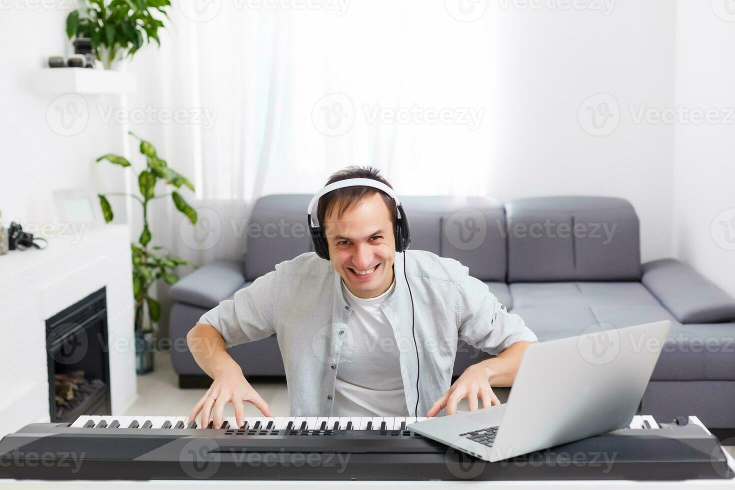 Man playing music with piano and laptop photo