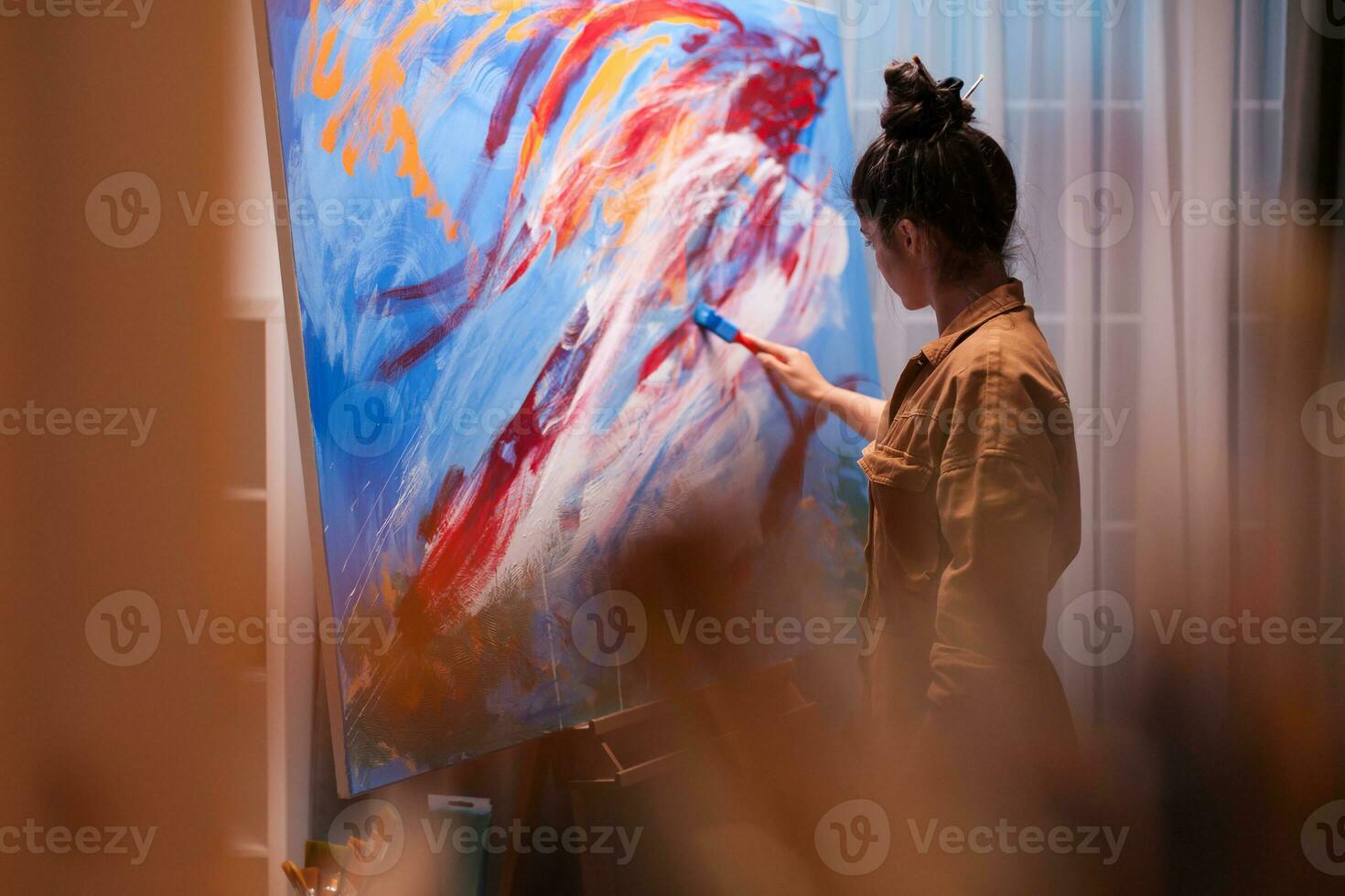 Woman with imagination painting a masterpiece in art workshop. Modern artwork paint on canvas, creative, contemporary and successful fine art artist drawing masterpiece photo