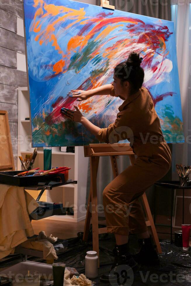 Painting with finger on canvas in art workshop with oil paint. Modern artwork paint on canvas, creative, contemporary and successful fine art artist drawing masterpiece photo