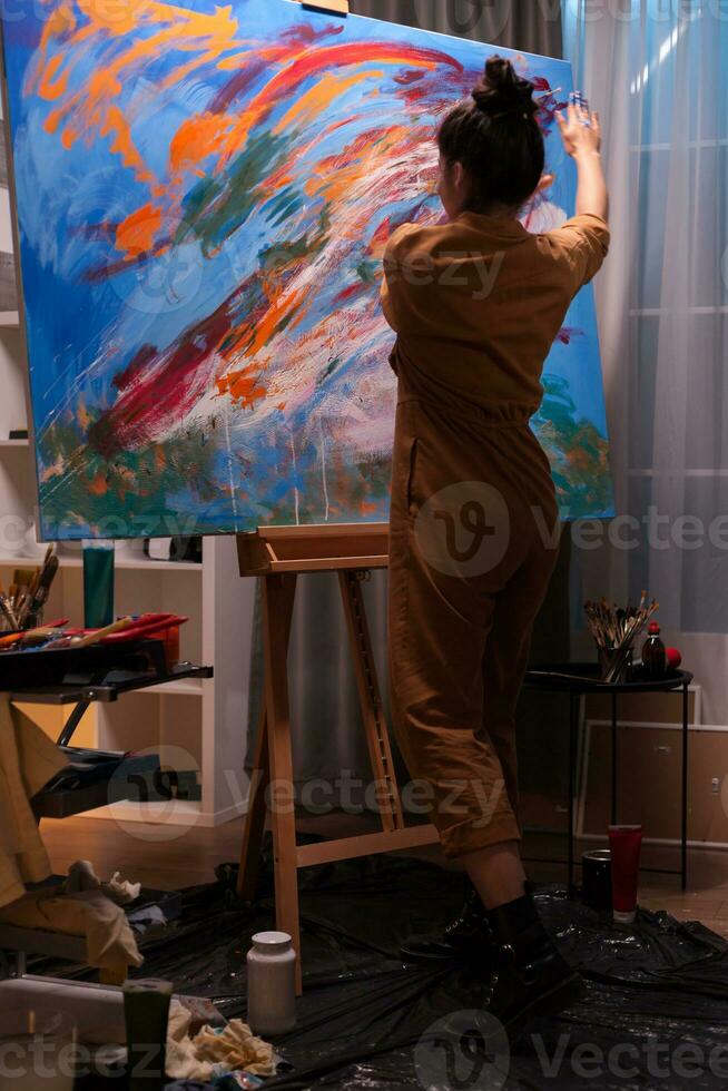 Artist painting with hands creating a masterpiece on large canvas. Modern artwork paint on canvas, creative, contemporary and successful fine art artist drawing masterpiece photo