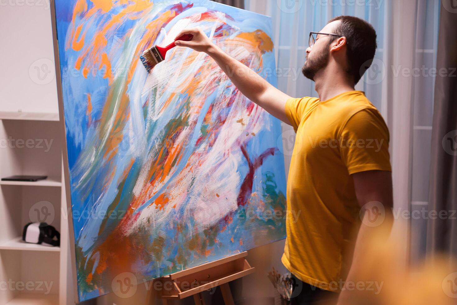 Man painting a masterpiece on large canvas in art studio. Modern artwork paint on canvas, creative, contemporary and successful fine art artist drawing masterpiece photo