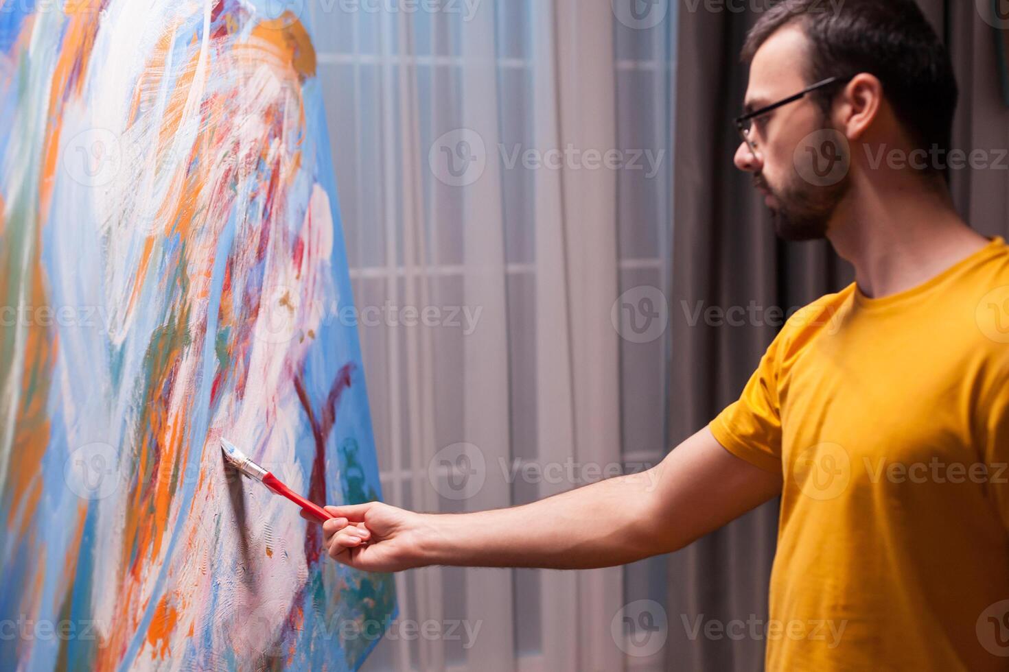 Fine art painter working on large painting in art studio. Modern artwork paint on canvas, creative, contemporary and successful fine art artist drawing masterpiece photo