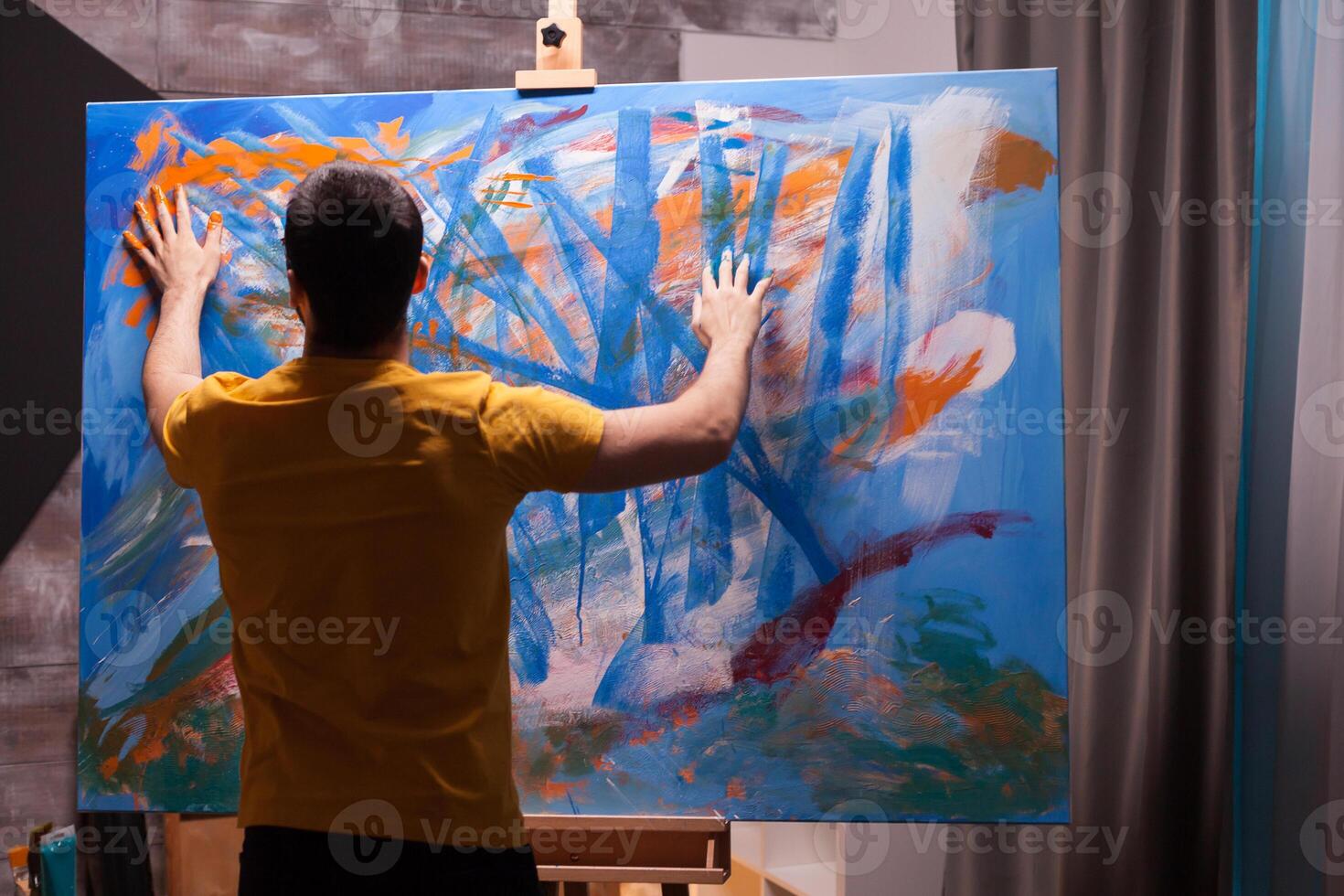 Artist painting with fingertips on large canvas in art studio. Modern artwork paint on canvas, creative, contemporary and successful fine art artist drawing masterpiece photo